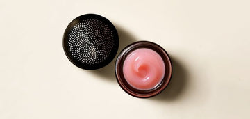 Moisture lock glossy lip balm on a cream background.